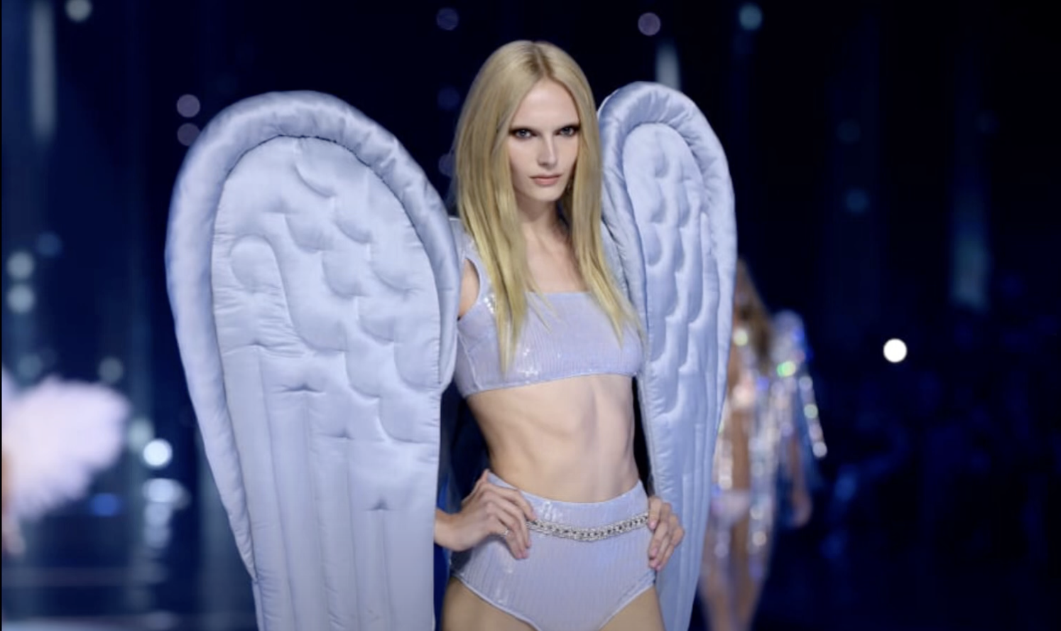 Two Trans-Identifying male models walk the runway at a Victoria’s Secret fashion show